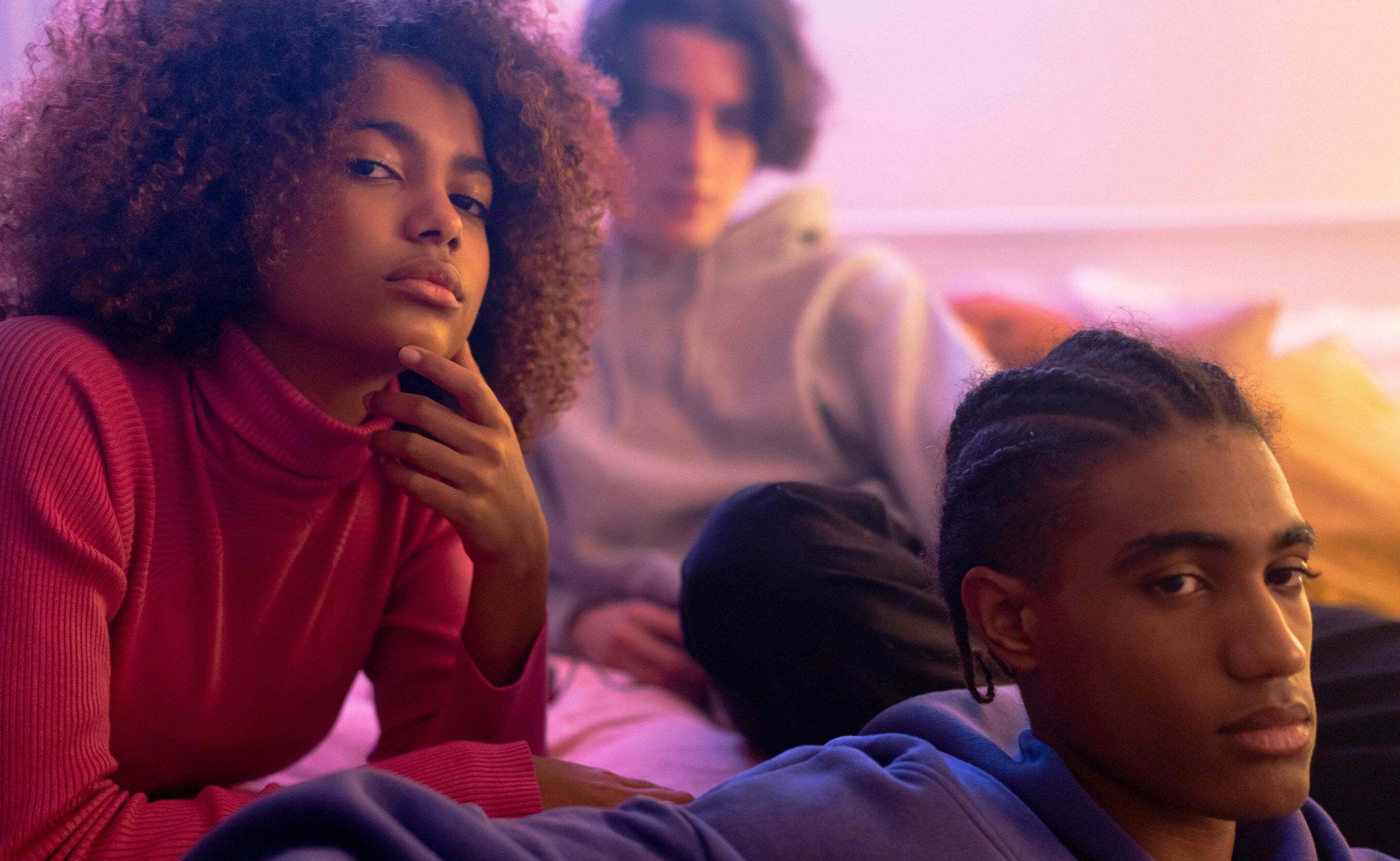 Young people of varied races, looking off to to the distance with worried faces.