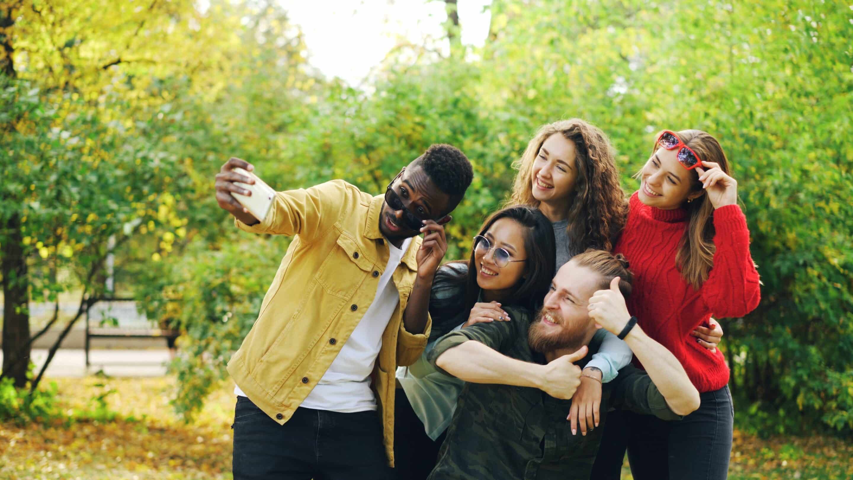 Group of young people of varying sexes and races, posing for a selfie. 
